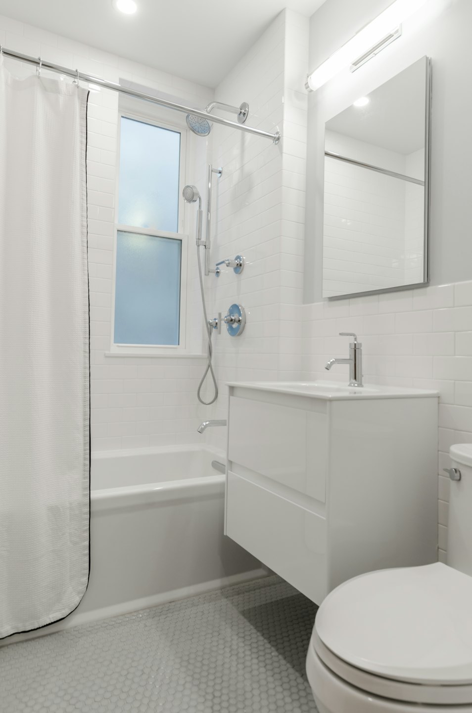 Modern white bathroom with a bathtub and vanity.