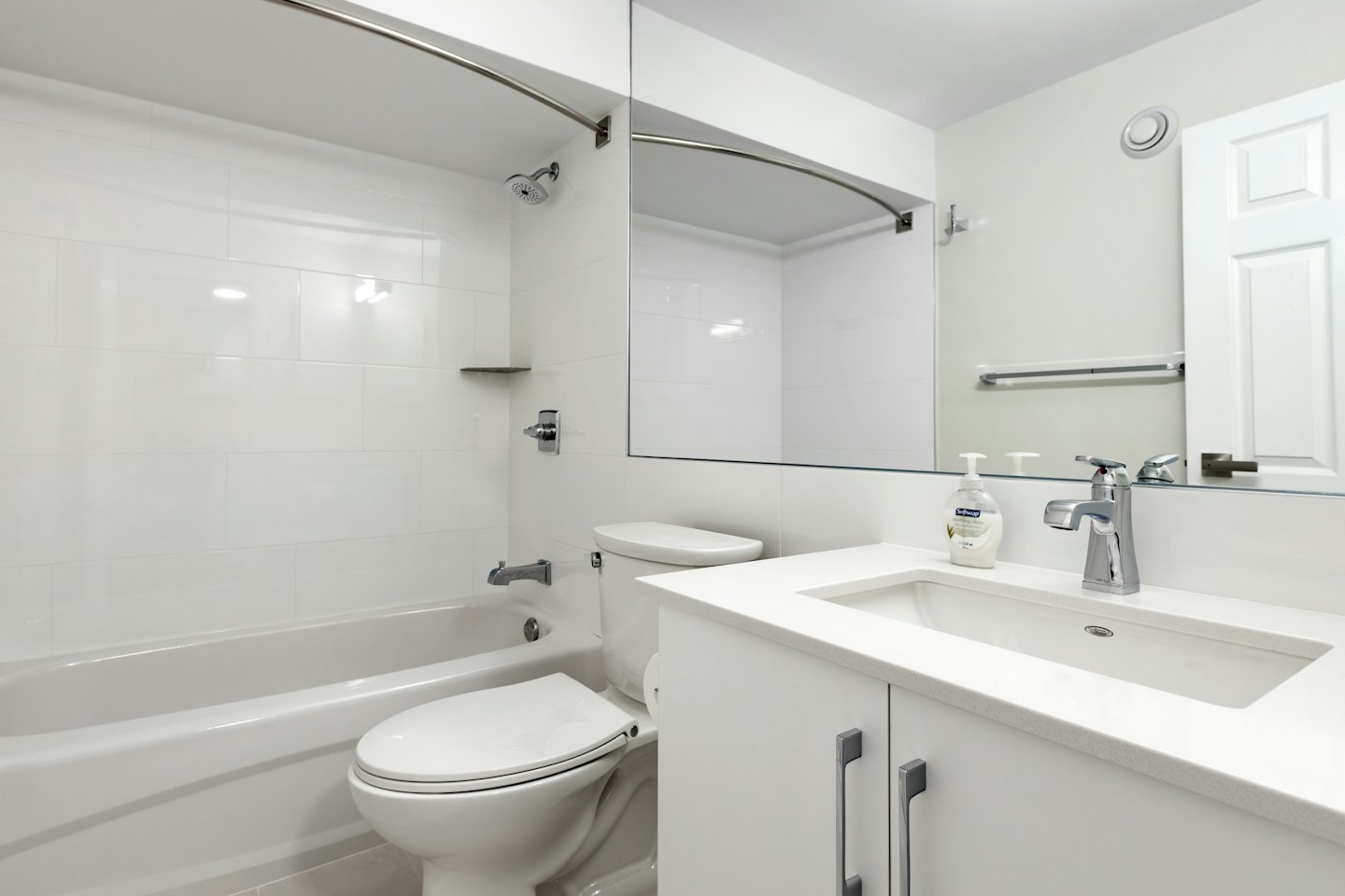 Modern bathroom featuring a porcelain bathtub, vanity, and sink.